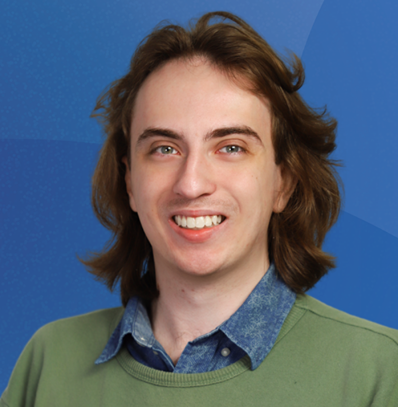 Younger man with wavy long hair and business attire