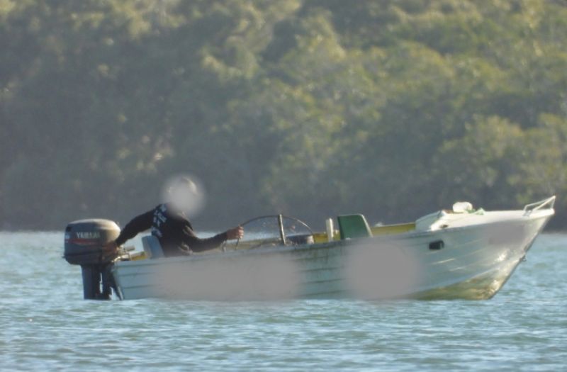 Man with a blurred face is on a boat on the water