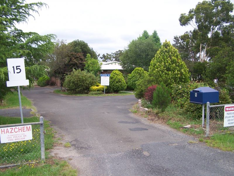 Driveway entrance to the Applethorpe Research Facility, with site signage, a mailbox and landscaped trees.