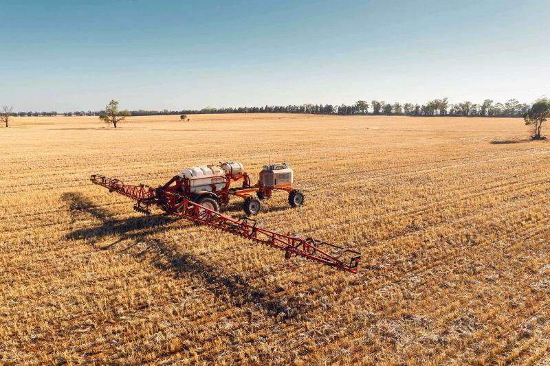 Farm machinery moving over the top of a golden crop