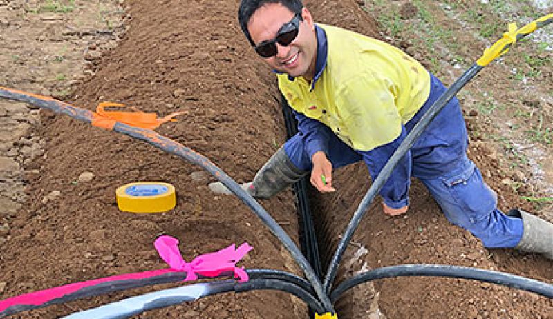 A farmer installing irrigation and fertigation equipment on a field to improve water management