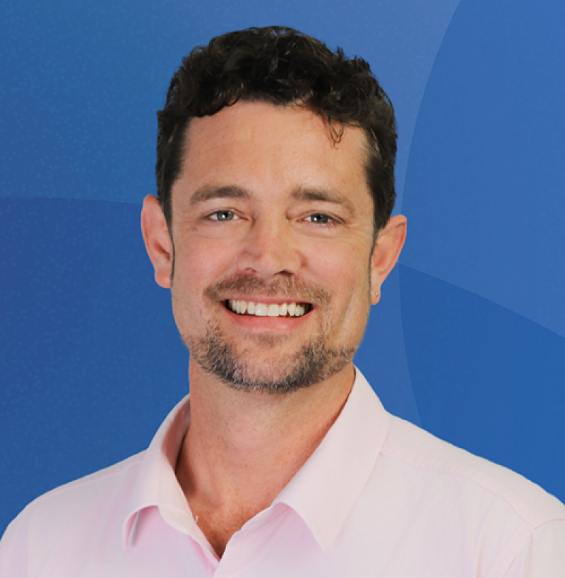 Man with short beard smiles at camera