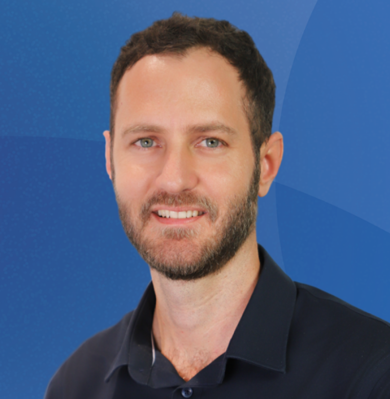 Man with dark hair and beard smiling