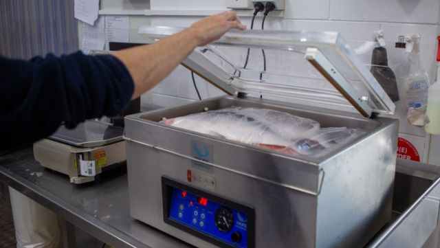 Wild-caught Queensland fish being wrapped and vacuum sealed in plastic